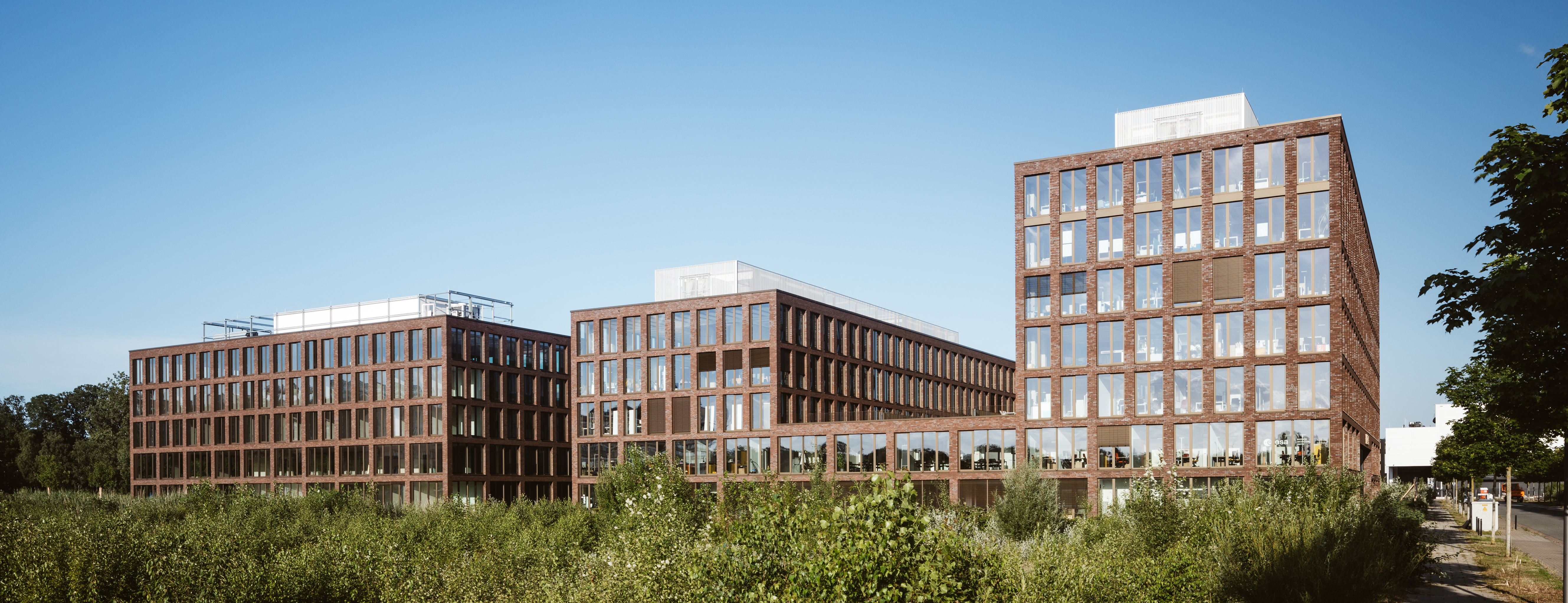 Ein großes Bürogebäude mit unterschiedlicher Höhe und zwischen zwei und sieben Stockwerken aus braunem Stein. - Quelle: WFB/Jan Meier