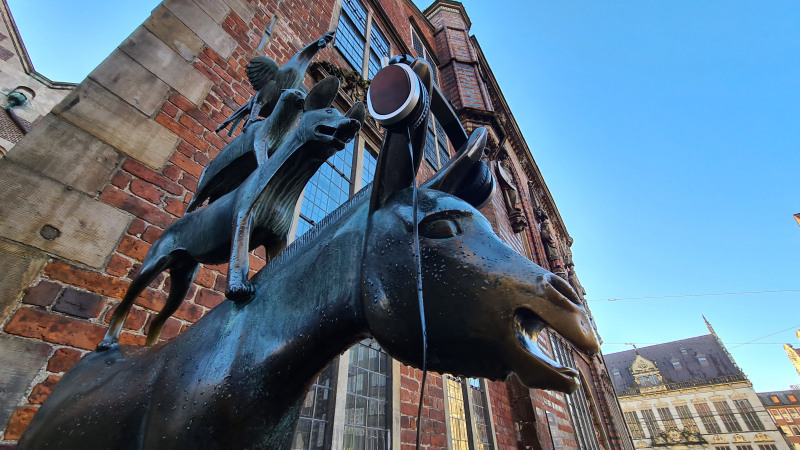 Die Statue der Bremer Stadtmusikanten vor dem Rathaus – der Esel trägt einen Kopfhörer.