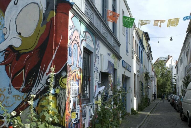 Eine Wohnstraße im Bremer Viertel zeigt bunte Straßenkunst an einer Hausfassade.