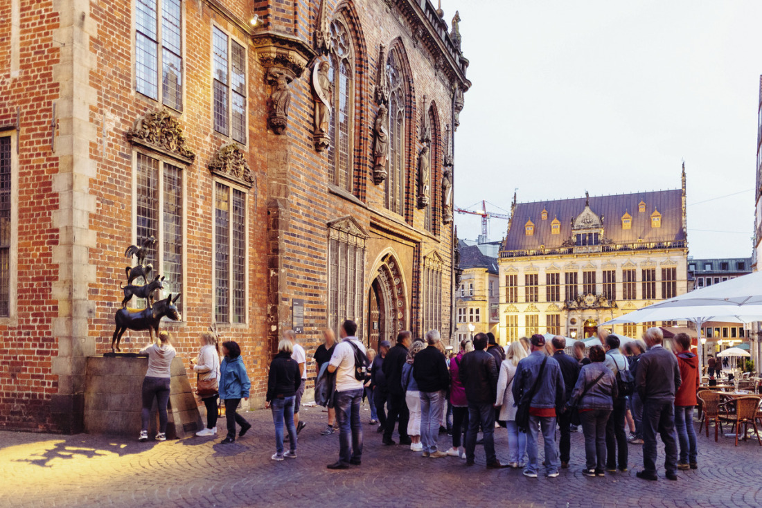 Eine Gruppe Tourist:innen vor den Bremer Stadtmusikanten