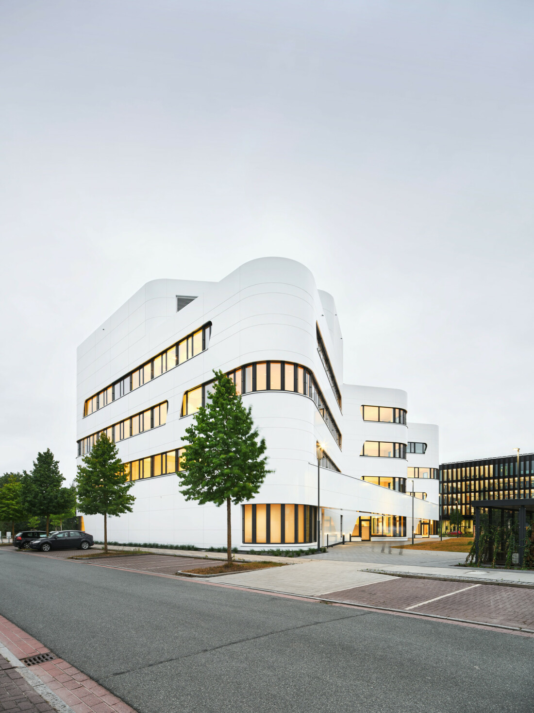 Ein futuristisches weißes Gebäude mit geschwungenen Außenlinien.