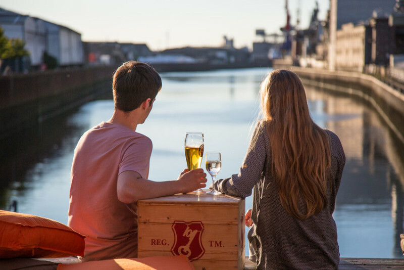 Two people sitting outside and drinking beer