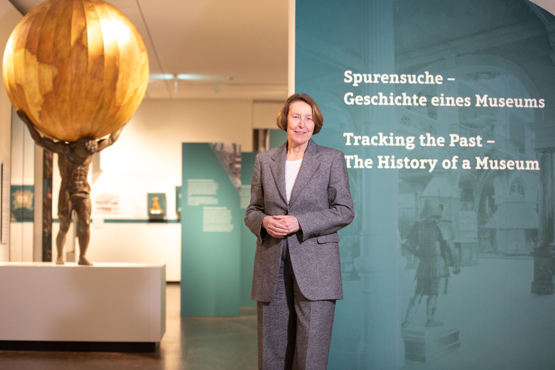 Prof. Dr. Wiebke Ahrndt steht vor einer Wand mit dem Schriftzug "Spurensuche - Geschichte eines Museums"