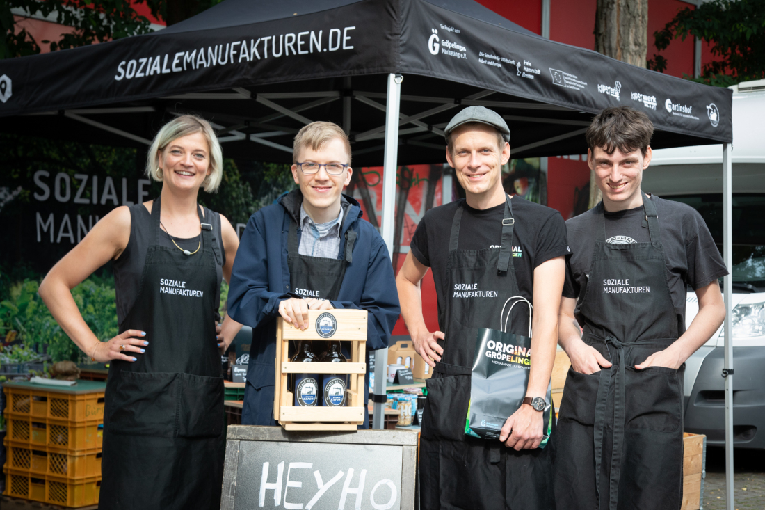Projektleiterin von „Soziale Manufakturen“ Svenja Weber (links) mit ihrem Team auf einem Wochenmarktstand.